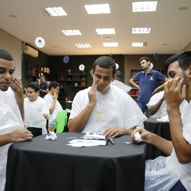 Na 1ª, da esquerda para a direita, um colaborador do Boticário e o educando Marco Antônio, o profissional está colocando um creme facial na mão do educando. Na 2ª, há o educando Dudu, ele passa creme em sua face. Na 3ª, os educandos, de costas, Pietro, de frente, Matheus, de lado, Pedro Branquinho. Eles estão de frente a uma mesa e sentam em cadeiras. Na 4ª, da esquerda para a direita, os educandos, Marco Antônio, Kauan, e Ryan. Eles passam creme em suas faces. Na 5ª, em destaque, uma colaboradora do Boticário, ela fala em cima de um palco. Na 6ª, da esquerda para a direita, os educandos, Marco Antônio, Kauan, e Ryan. Eles olham para o hidrante da Boticário. Na 7ª, há os colaboradores do Boticário e educandos e colaboradores da Adevirp, eles sorriem para a foto.